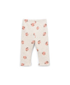 A pair of baby leggings in a warm cream color, featuring a scattered print of pink and orange ladybugs with tiny dark accents.