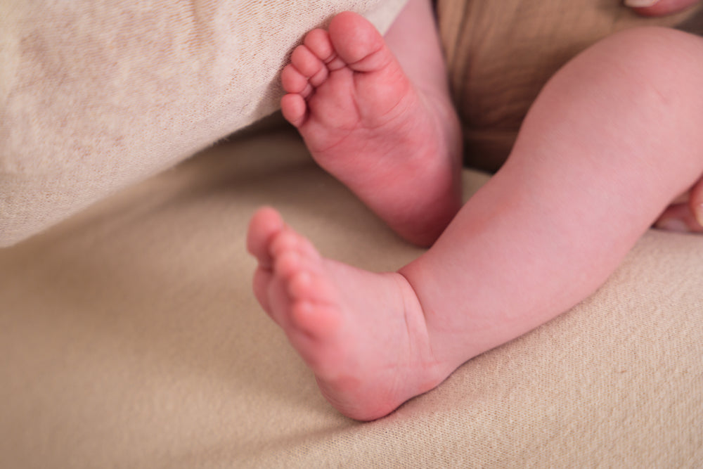 Close-up of a baby's feet on a beige surface