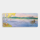 An open spread of the board book When Fall Comes showing an illustration of a lake landscape at sunset, with a person in a small boat and a deer standing on the shore under autumn trees.