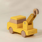 Wooden toy truck with a crane on a beige background