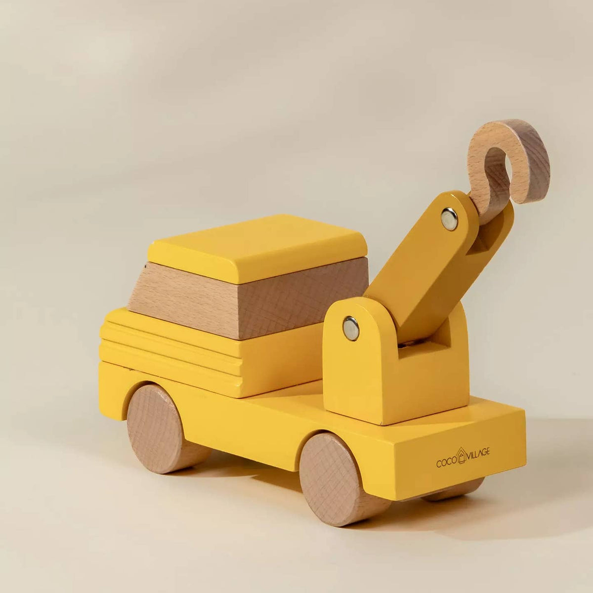 Wooden toy truck with a crane on a beige background
