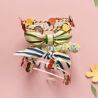 Three colorful headbands with decorative elements on a pink background