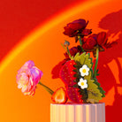 Decorative arrangement with flowers and a strawberry on a red background