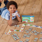 Child playing with colorful dominoes on a wooden floor