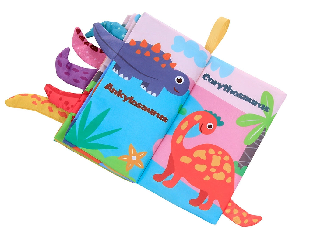 A colorful children's fabric book featuring dinosaur illustrations, including Aynkylosaurus and Corythosaurus, with soft tabs and a yellow ribbon bookmark on a white background.