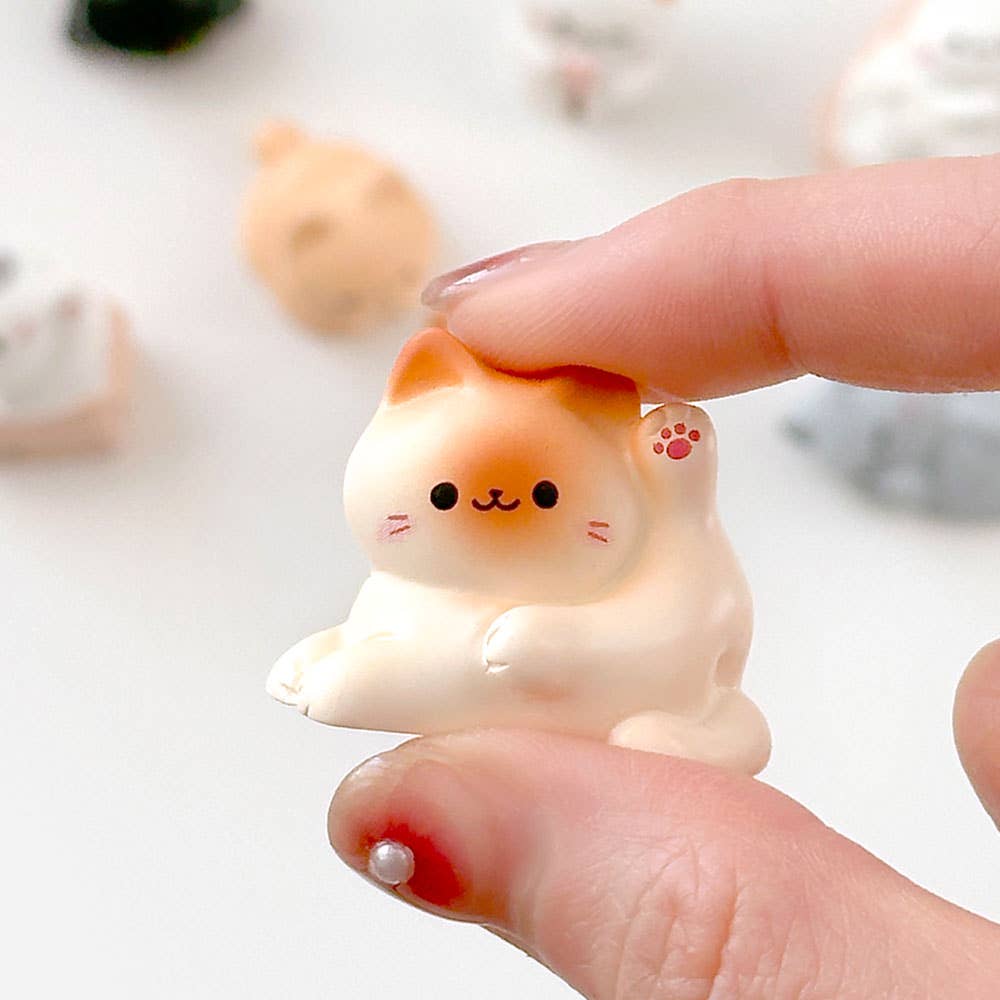 Small white dog figurine held between fingers with a blurred background