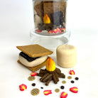 Miniature s'mores set with a campfire and marshmallows on a white background