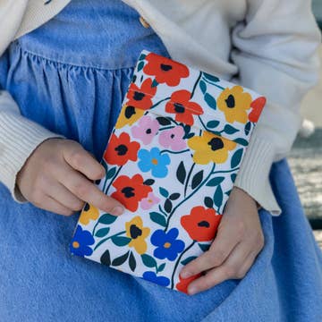 Person holding a colorful floral notebook