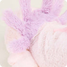 A close-up side view of the Pink Axolotl by Warmies plush toy, focusing on its fluffy purple external gills and soft light pink head.
