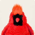 A close-up view of the Red Cardinal by Warmies plush toy, showcasing its bright red fuzzy fur, textured crest on top of its head, and a black face with a red beak.