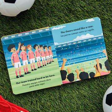 Children's book open on grass with soccer-themed illustrations