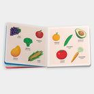 Open book showing illustrations of fruits and vegetables with labels on a white background