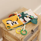 Children's soft book with animal illustrations on a wooden surface