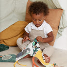 Child playing with a colorful toy on a bed