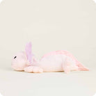 A side-profile view of the Pink Axolotl by Warmies plush toy resting on a neutral surface, showing its light pink body, stitched face, and purple feathery gills.