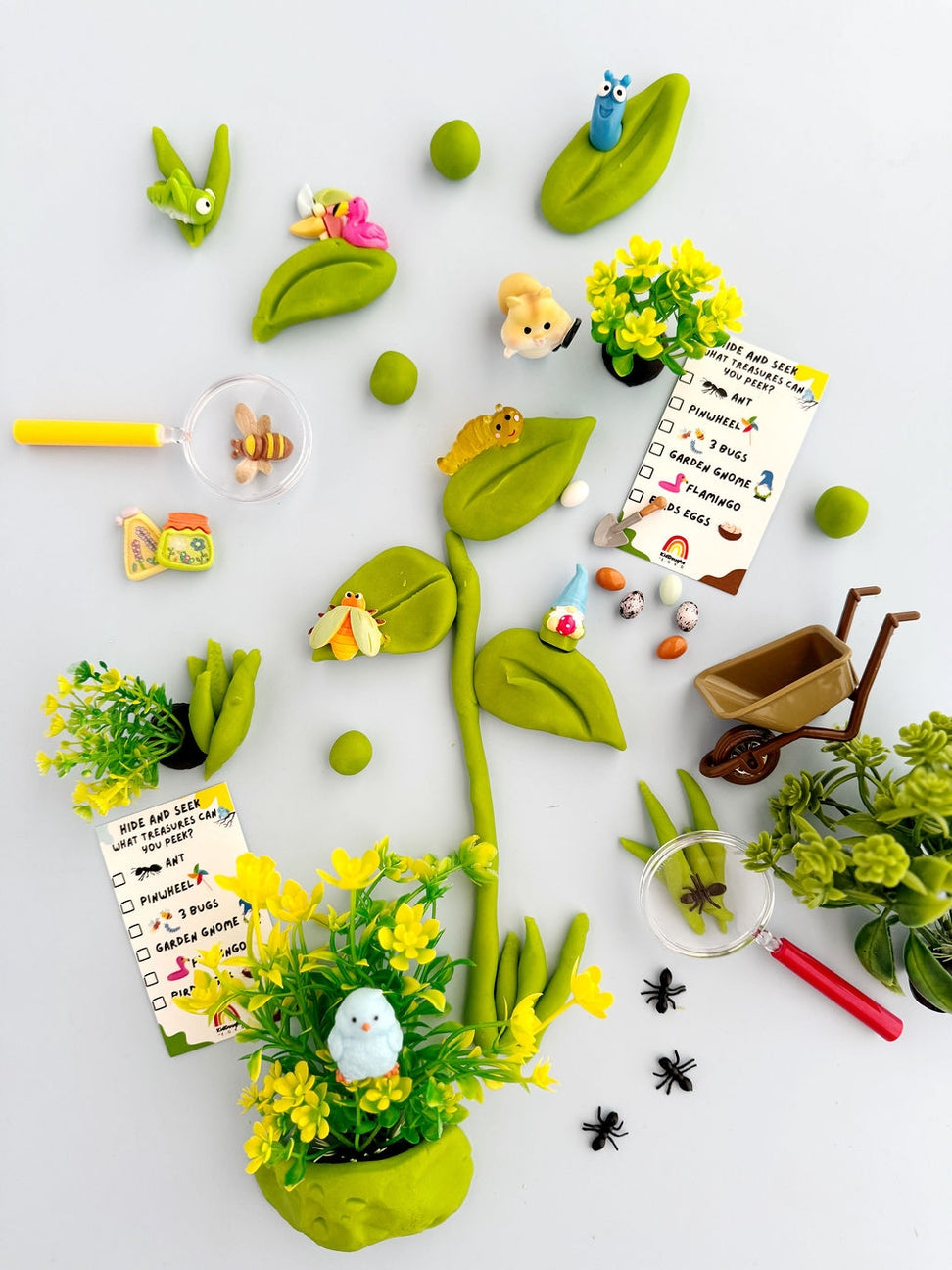 Playful garden scene with toy plants, animals, and accessories on a light background