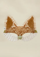 Fabric bow with brown pattern and white ruffles on a beige background