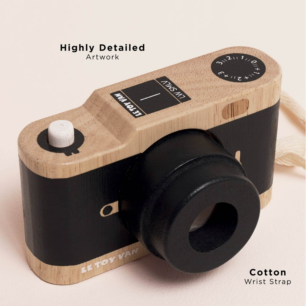 Toy camera with wooden and black design on a light pink background