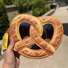 Heart-shaped pretzel purse held by a hand outdoors