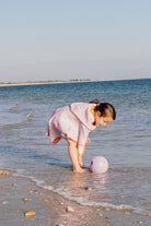 Child playing with a ball in shallow water at the beach