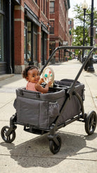 Child in a gray stroller on a city street
