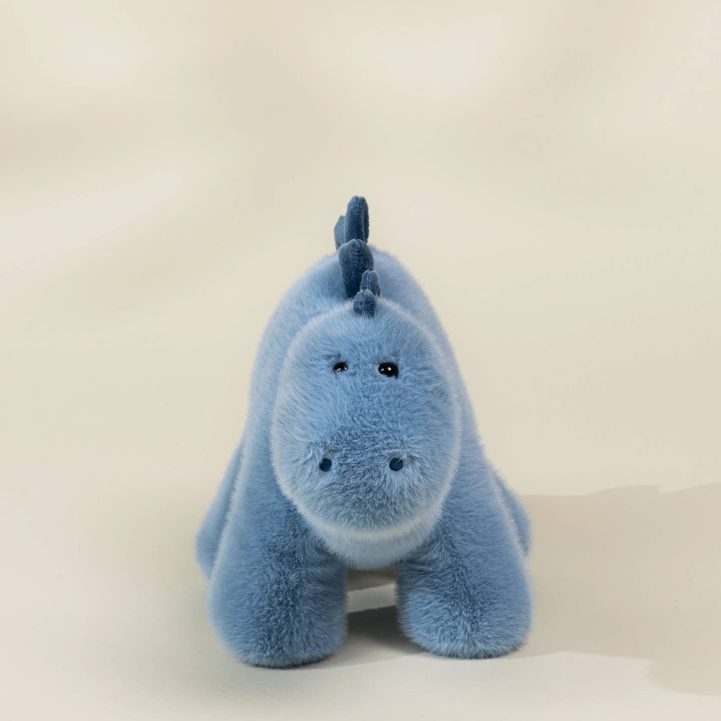 Blue plush toy with a unicorn design on a white background