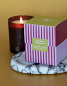 Candle with a striped box labeled 'Lavender Bergamot' on a marble coaster.