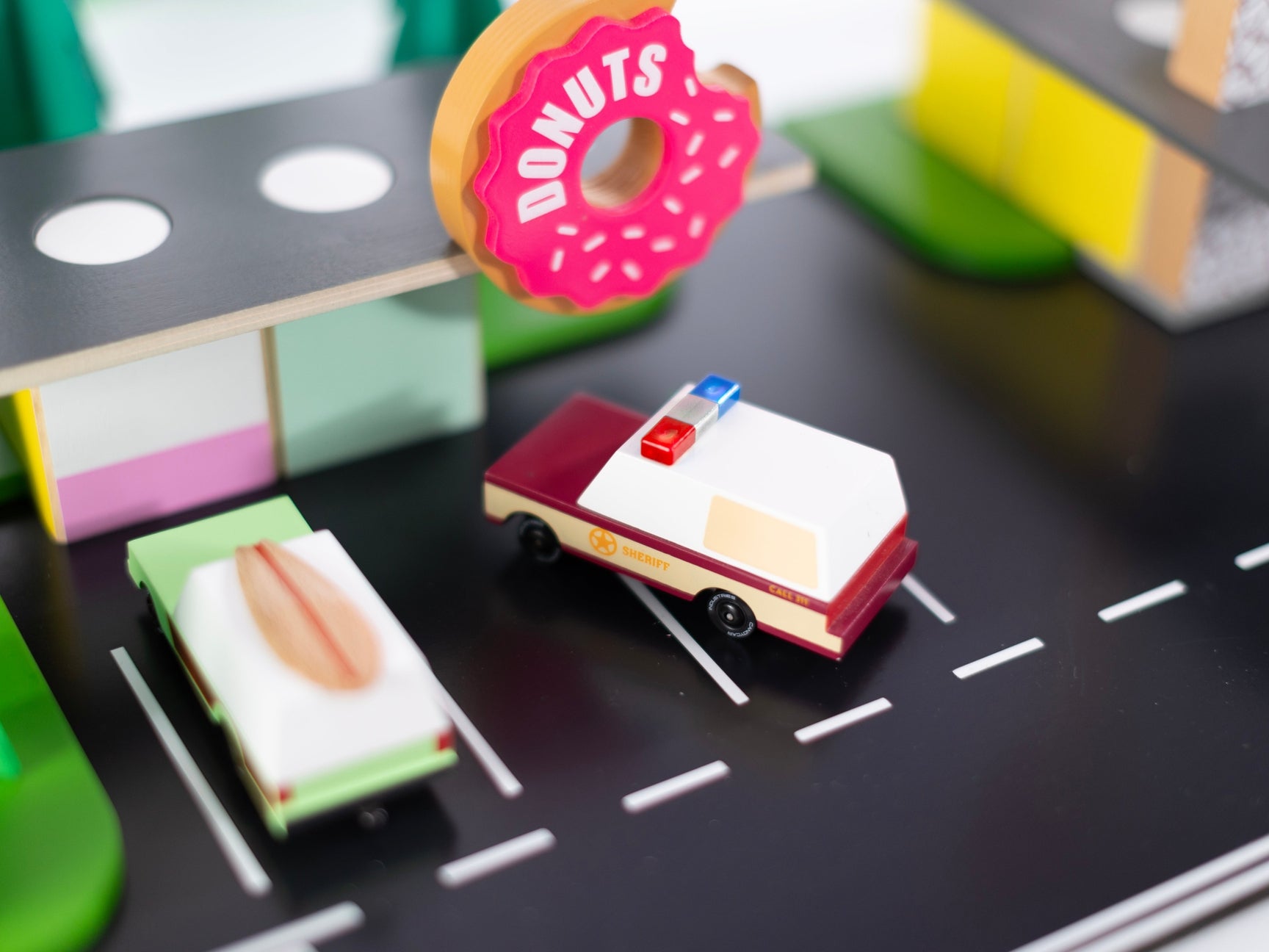 Toy car on a miniature road with donut-themed obstacles
