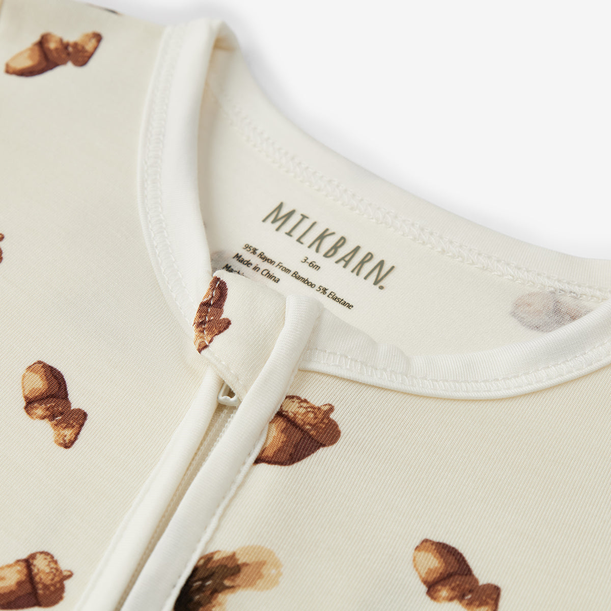 Baby outfit with acorn pattern and 'Milkbarn' branding on a white background
