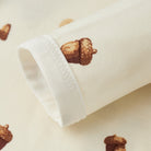 Close-up of a white fabric roll with acorn pattern on a beige background