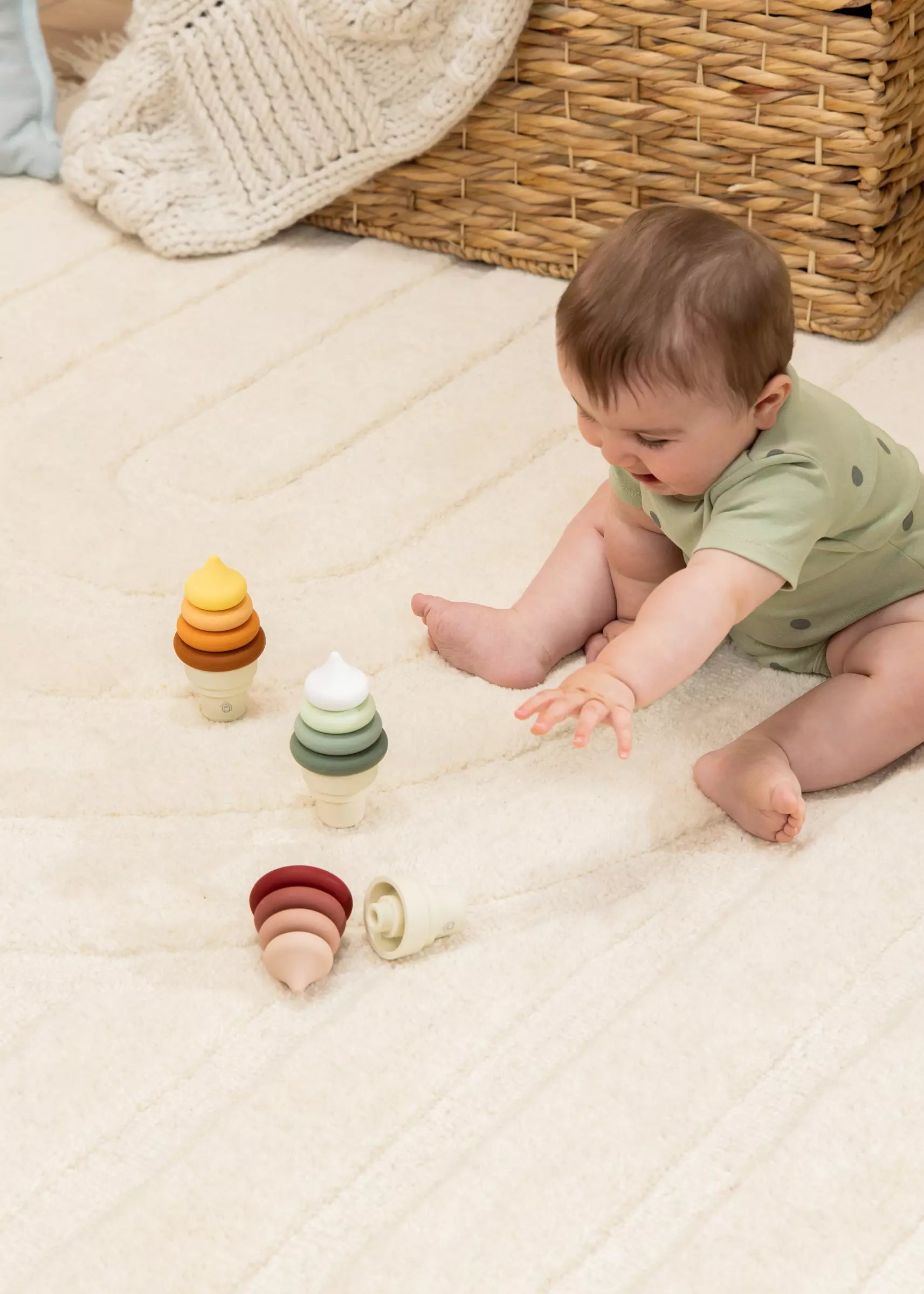 Baby playing with wooden toys on a soft surface