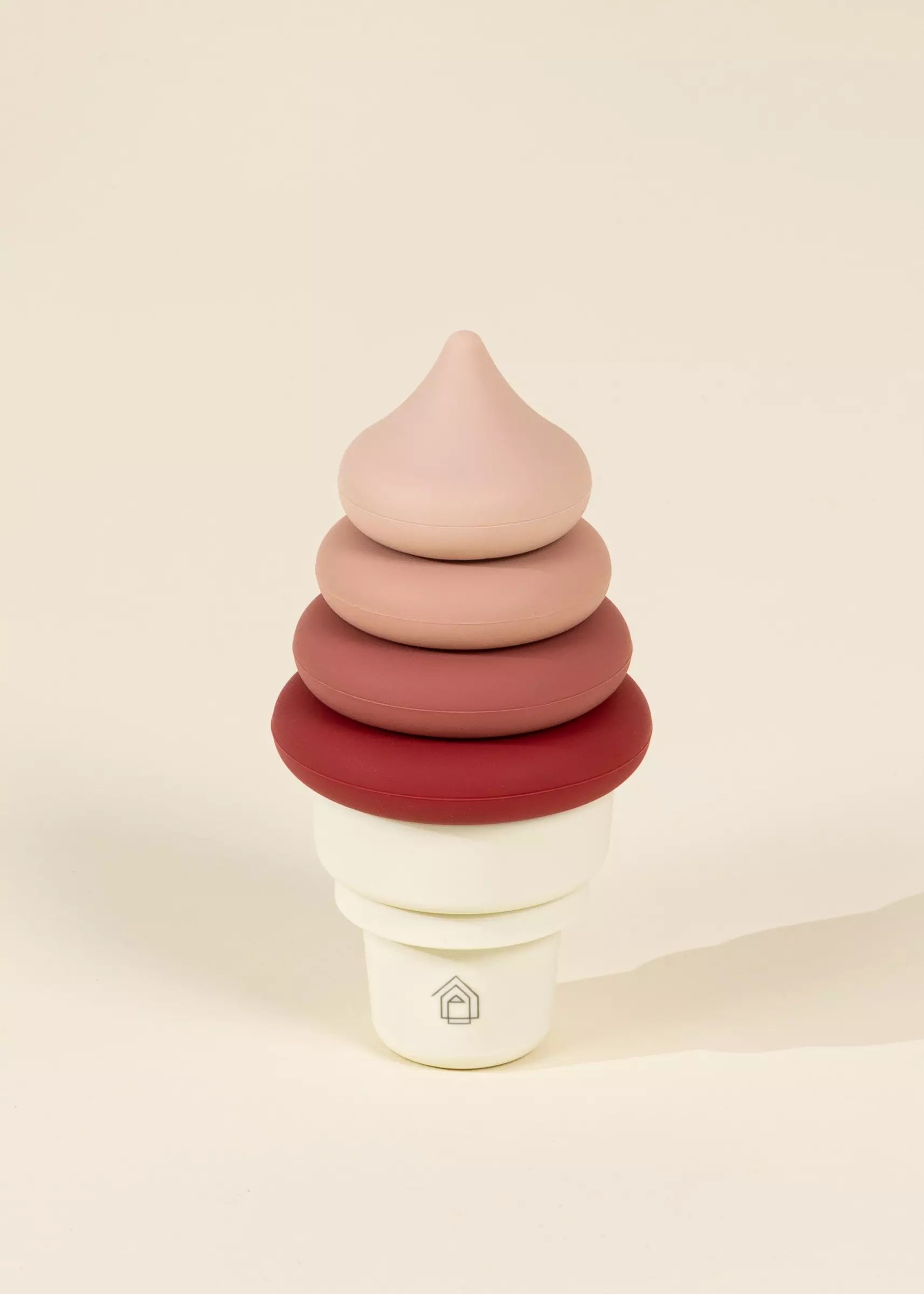 Stack of colorful wooden ice cream cones on a beige background