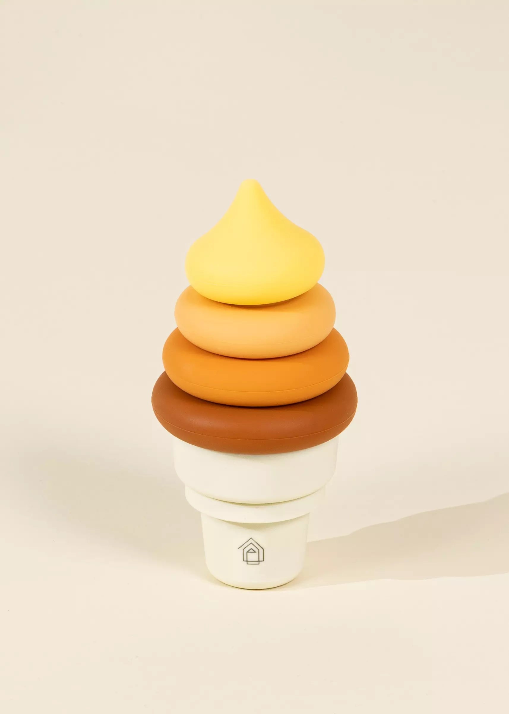 Stack of colorful rings on a white base with a yellow top, on a beige background.