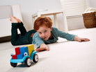 Child playing with a toy train on a carpeted floor