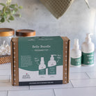 Earth Mama Belly Bundle Pregnancy Kit packaging on a kitchen counter with baby care products.