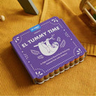 Purple book titled 'El Tummy Time' on a yellow textured surface