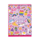 A pink spiral-bound sketchbook with a colorful cartoon illustration pattern, featuring the words 'SKETCH BOOK' on the cover, photographed against a plain white background.