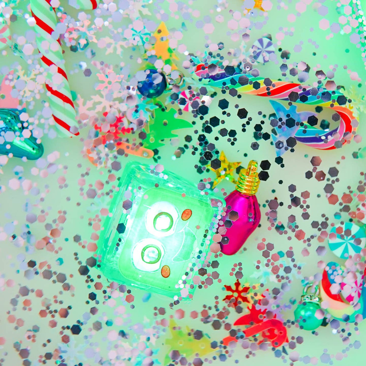 Colorful Christmas-themed decorations on a glittery background