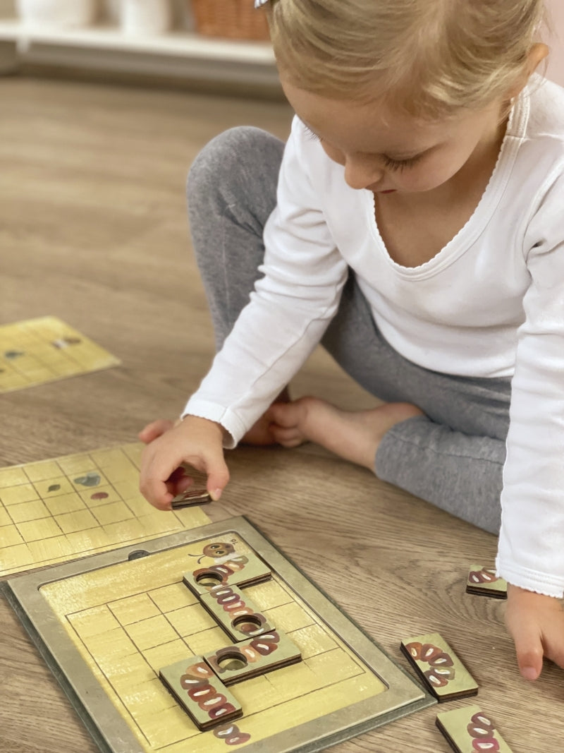 Child playing with a board game on a wooden floor