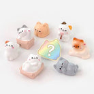 Set of cute cat-shaped desk toys with a colorful question mark icon on a white background