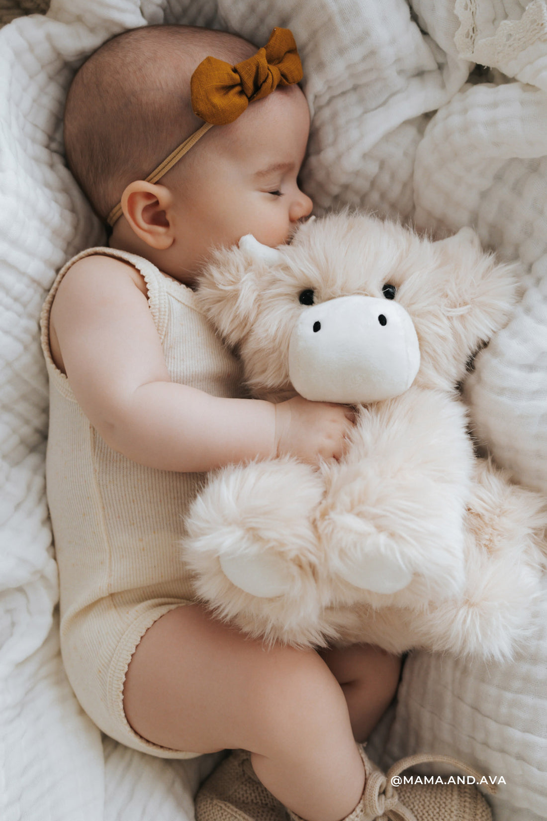 Baby sleeping with a teddy bear on a soft blanket