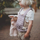 Child holding a plush toy outdoors