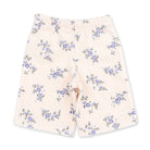 A pair of baby shorts in a soft cream color, featuring an all-over print of small blue and purple flowers with green leaves, laid flat against a white background.