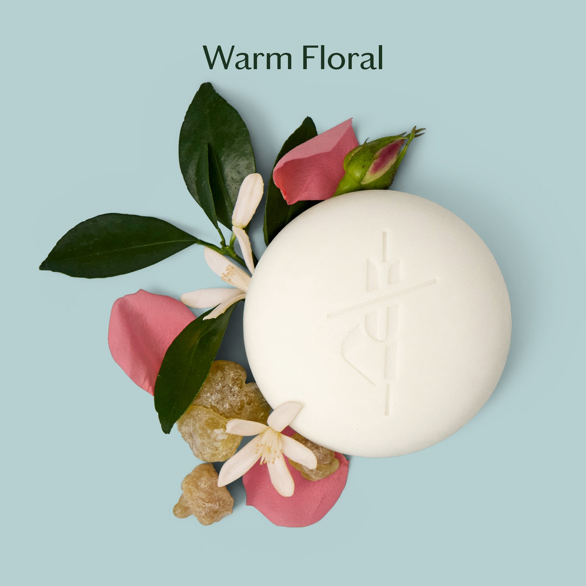 White spherical candle with pink flowers and green leaves on a light blue background, labeled 'Warm Floral'.