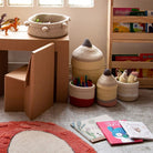 Children's play area with toys, books, and storage baskets on a carpeted floor.