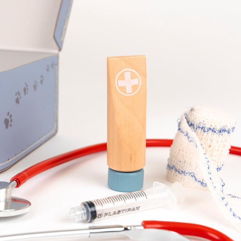 Wooden syringe with red and blue accents on a white surface