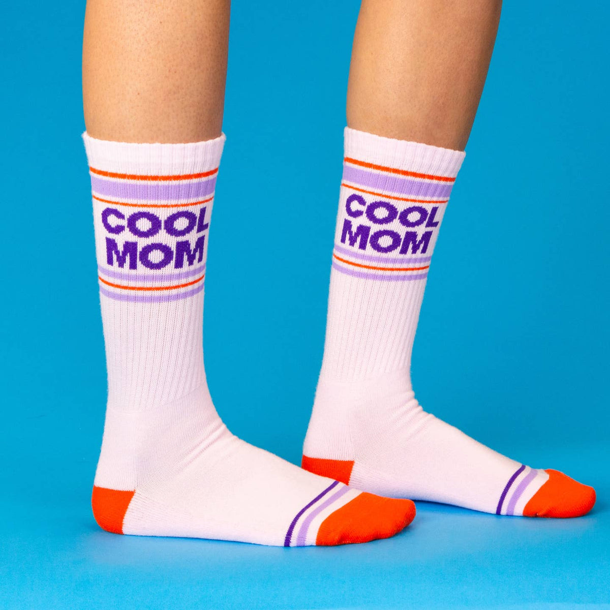 White socks with 'COOL MOM' text and colorful stripes on a blue background