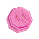 Pink hexagonal jewelry box with heart-shaped earrings on a white background