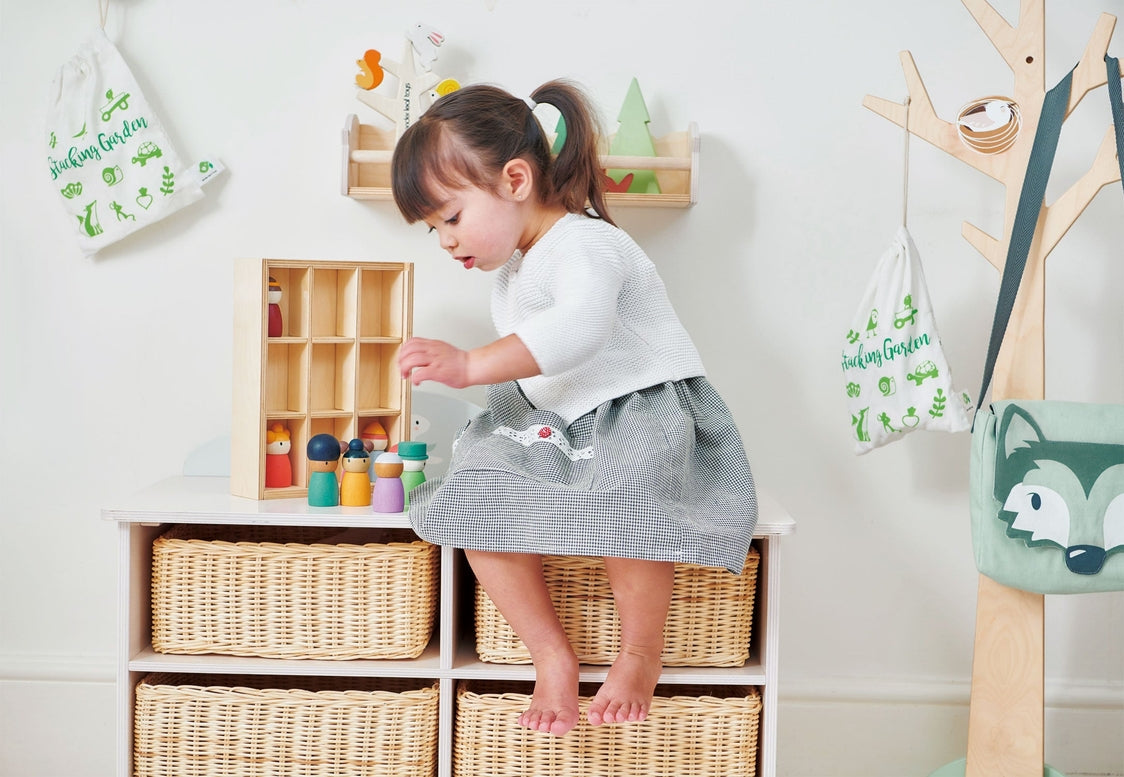 Child playing with toys in a room with wooden shelves and decor.
