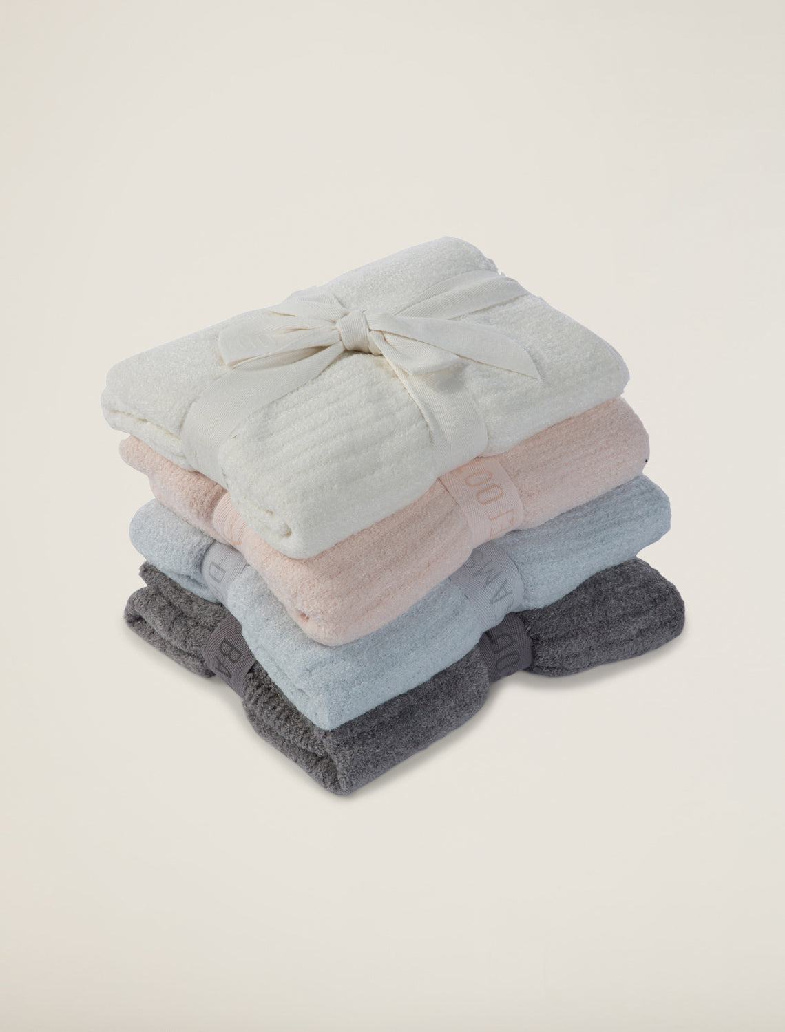Stack of folded clothes in light blue, pink, and gray on a beige background